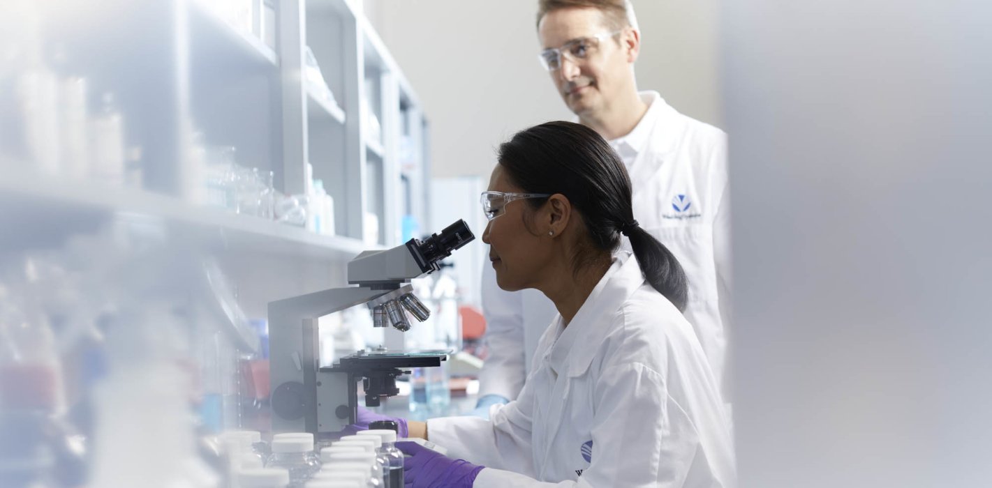 A female lab worker at a microscope