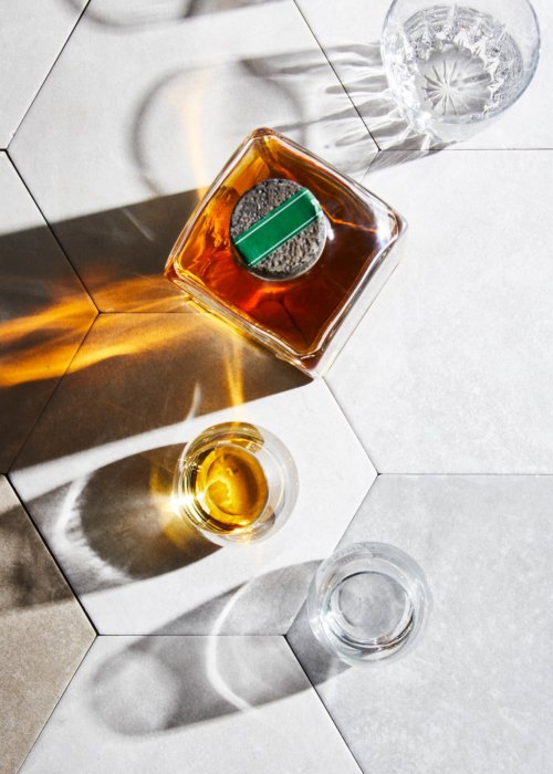 Tequila bottles on a hexagon surface with lights - cantera negra - drink photography