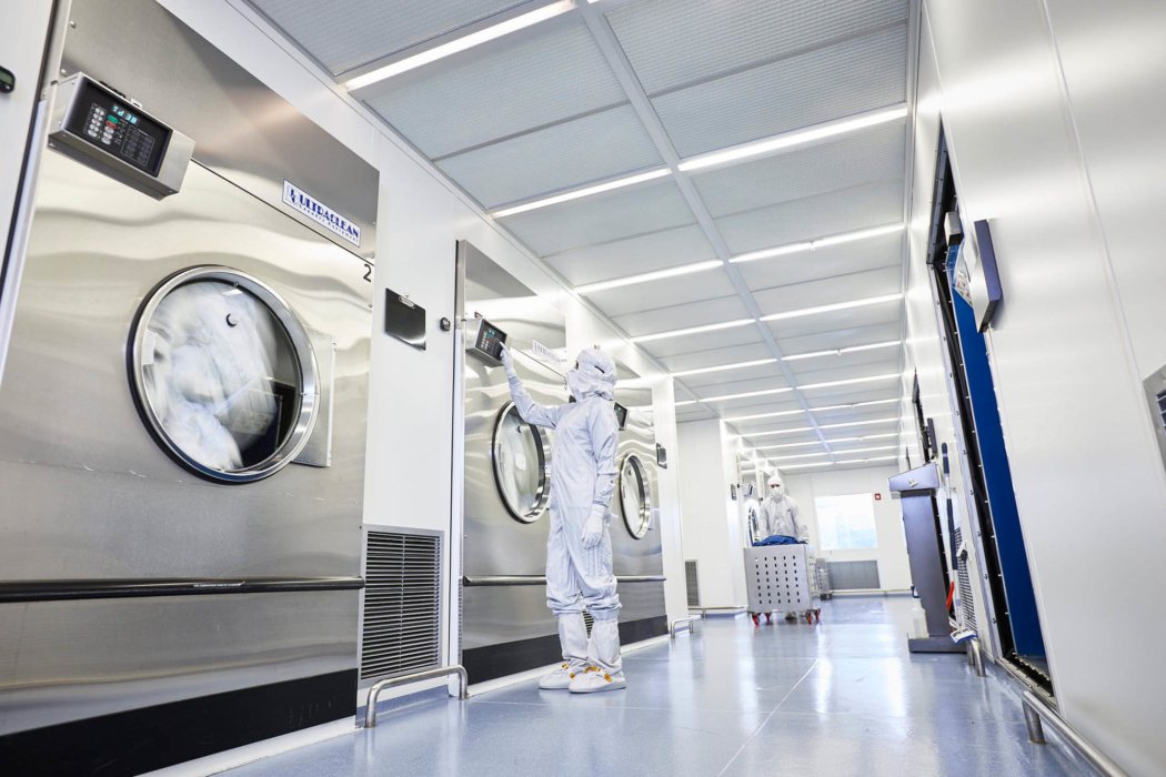 A person in cintas protective suit checking up on machine work apparel photography