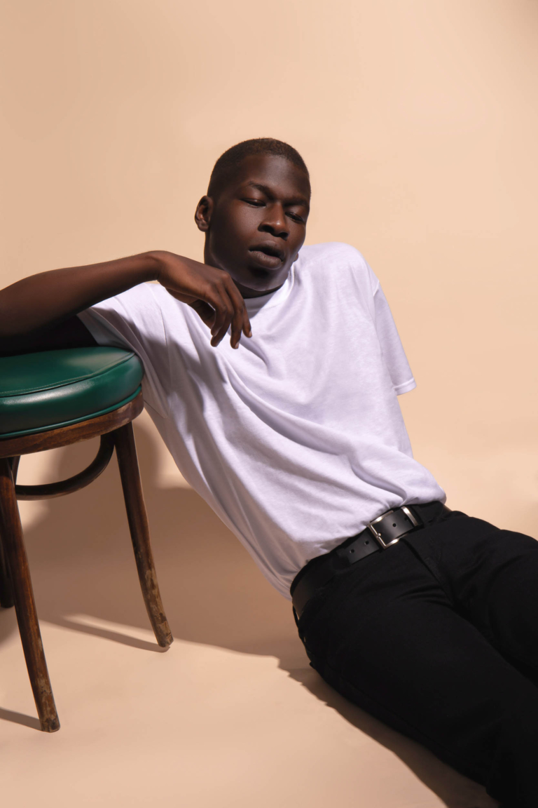 A man sitting on the floor leaning against a chair - modern photography - portrait photographer