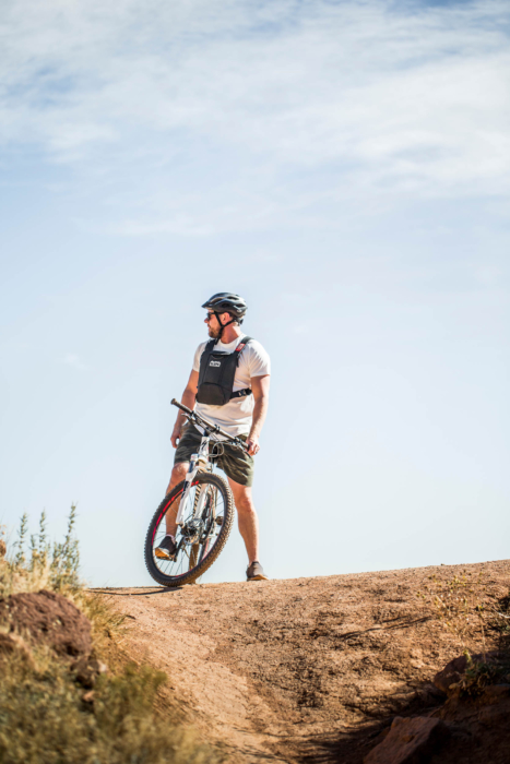 A man on the crest of a hill with his bike looking out - Denver lifestyle photography