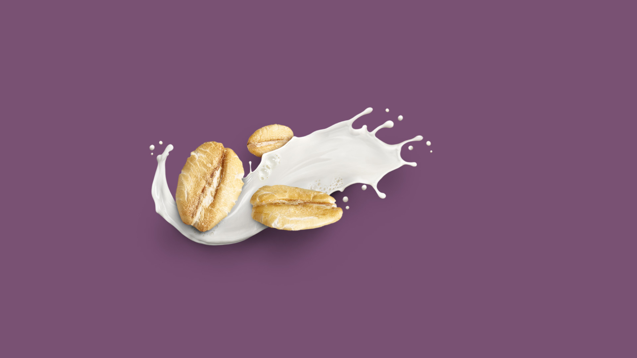 Almonds splashing into milk against purple background in breakfast beverage photography