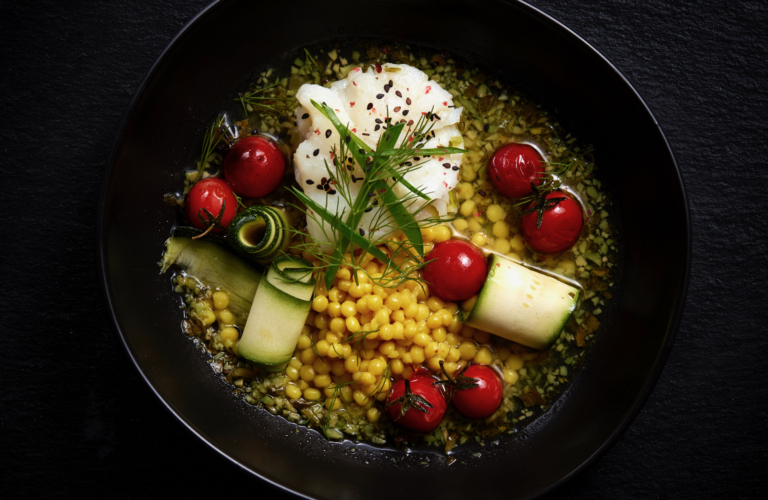 Overhead view of a gourmet bowl with corn, cherry tomatoes, burrata, and zucchini ribbons, photographed by OMS Photo, expert commercial food photographer.