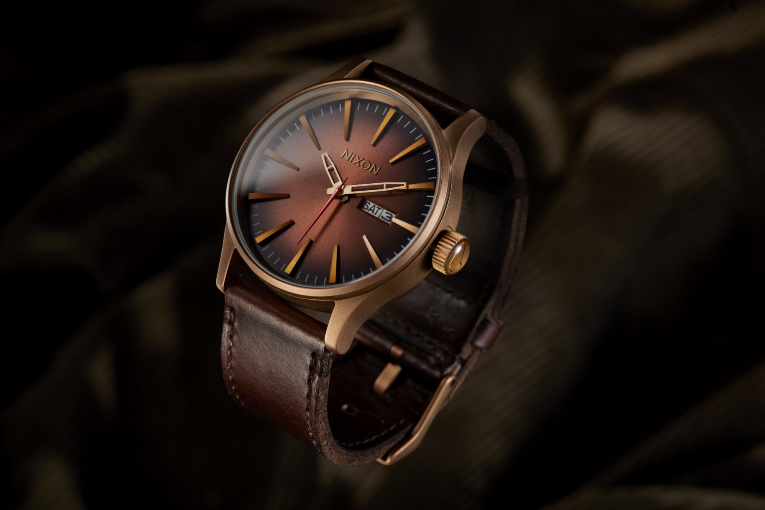 Luxury wristwatch with bronze dial photographed by OMS Photo using dramatic low-key lighting for high-end commercial product photography.