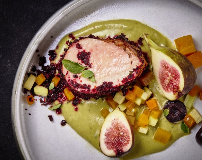 Gourmet plated pork tenderloin with figs, green purée, and diced vegetables, photographed by OMS Photo, expert commercial food photographer.