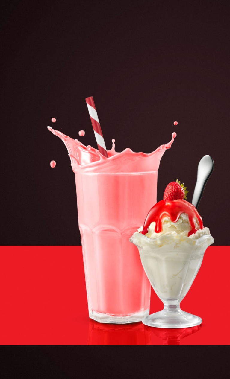 Strawberry milkshake with splash and whipped cream sundae captured using high-speed commercial beverage photography