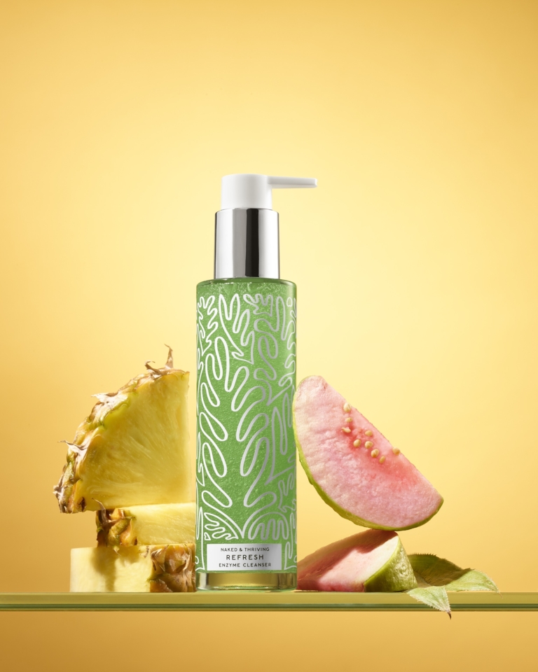 Naked & Thriving green botanical skincare collection with guava fruit on yellow background