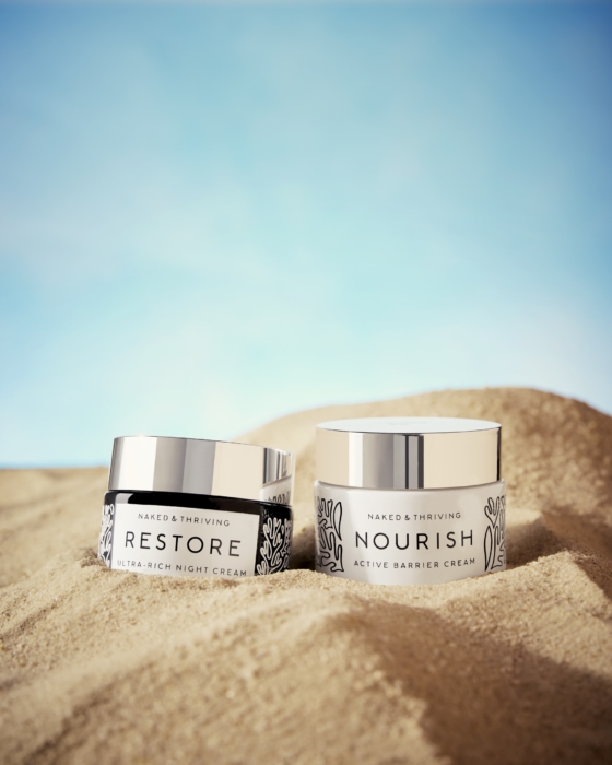 two containers of cream in the sand