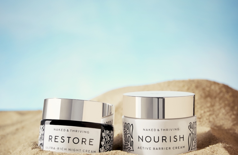 two containers of cream in the sand