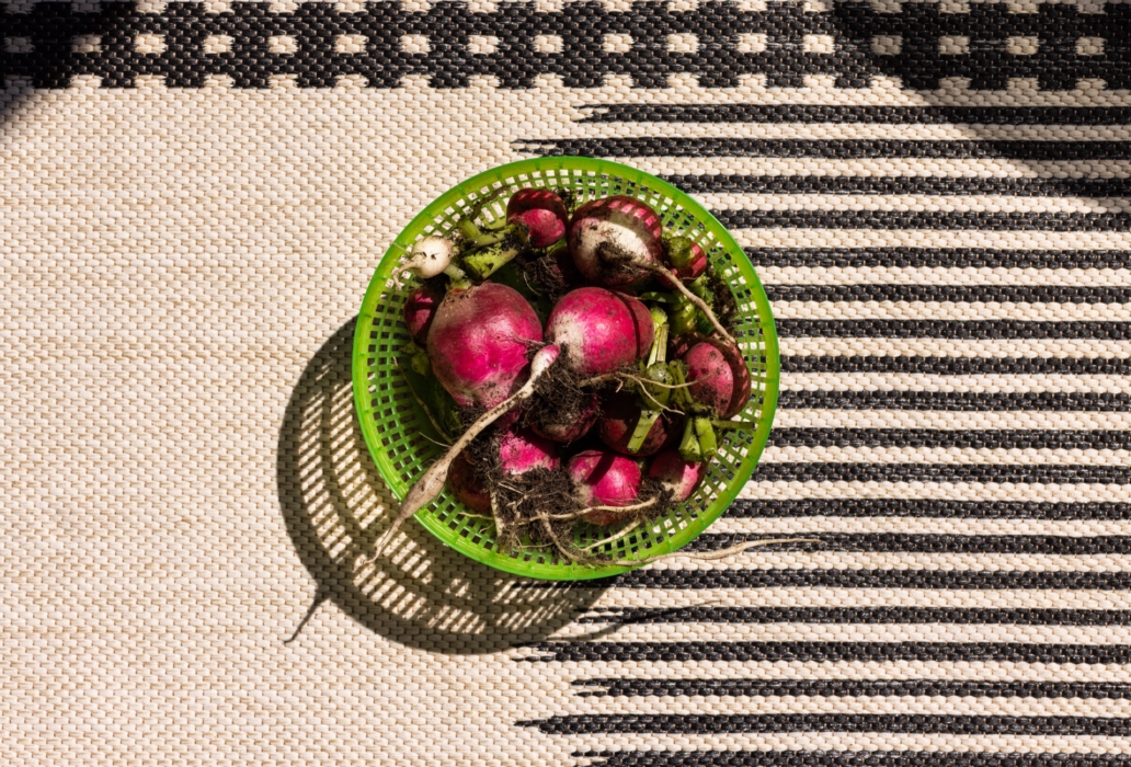 a basket of radishes on a rug