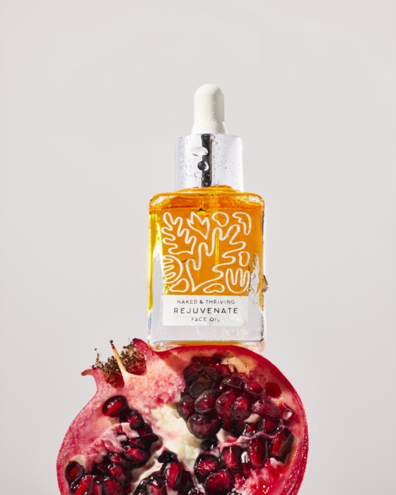 a bottle of oil on top of a pomegranate