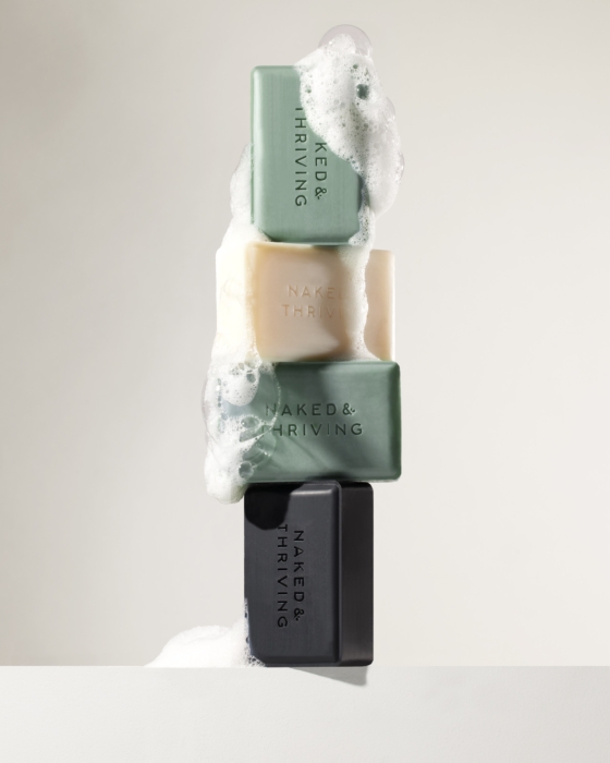 Stacked Naked & Thriving natural soaps with foamy suds, professionally styled and photographed by OMS Photography for commercial marketing.