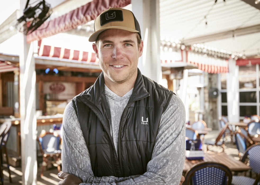 Hero shot of man wearing HUK performance apparel with modern bar-restaurant in background, captured for outdoor lifestyle and brand marketing by OMS Photography