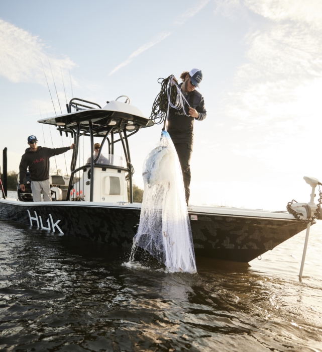 Anglers in HUK performance apparel actively fishing on river or lake, photographed for outdoor lifestyle and gear marketing by OMS Photography