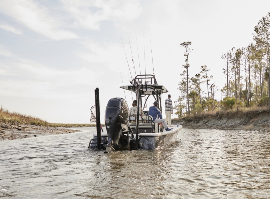Wide shot of three anglers on a boat surrounded by open water and natural landscape, captured for outdoor lifestyle and fishing campaigns by OMS Photography