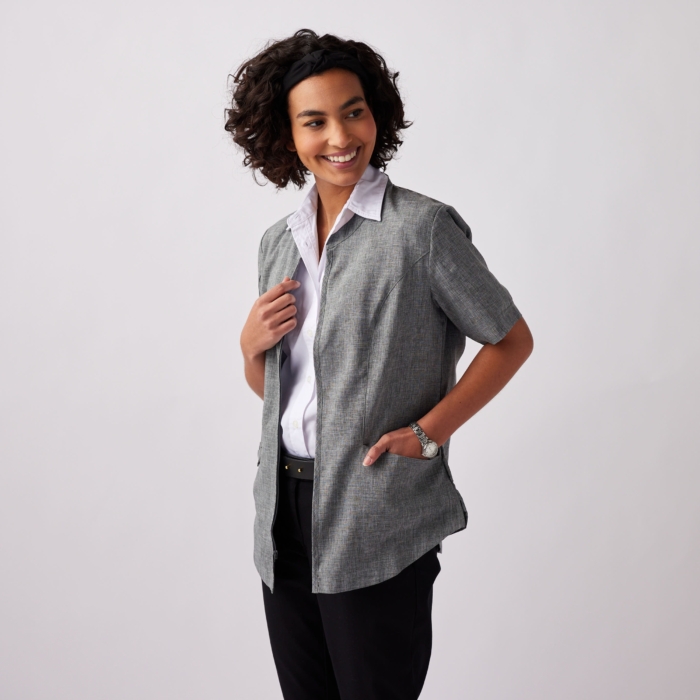 a woman smiling and holding her hand to her chest