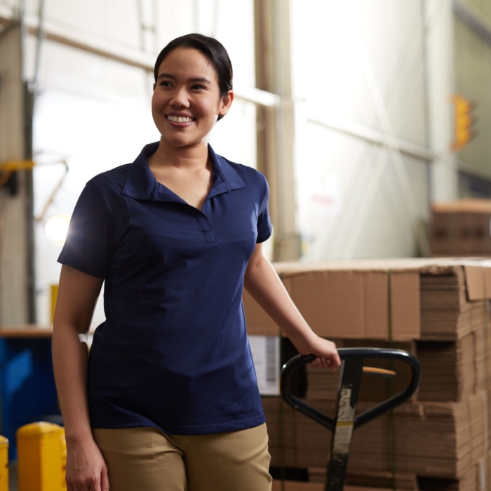 a woman smiling while pushing a pallet truck, Cintas, construction, workplace, jobsite, on location