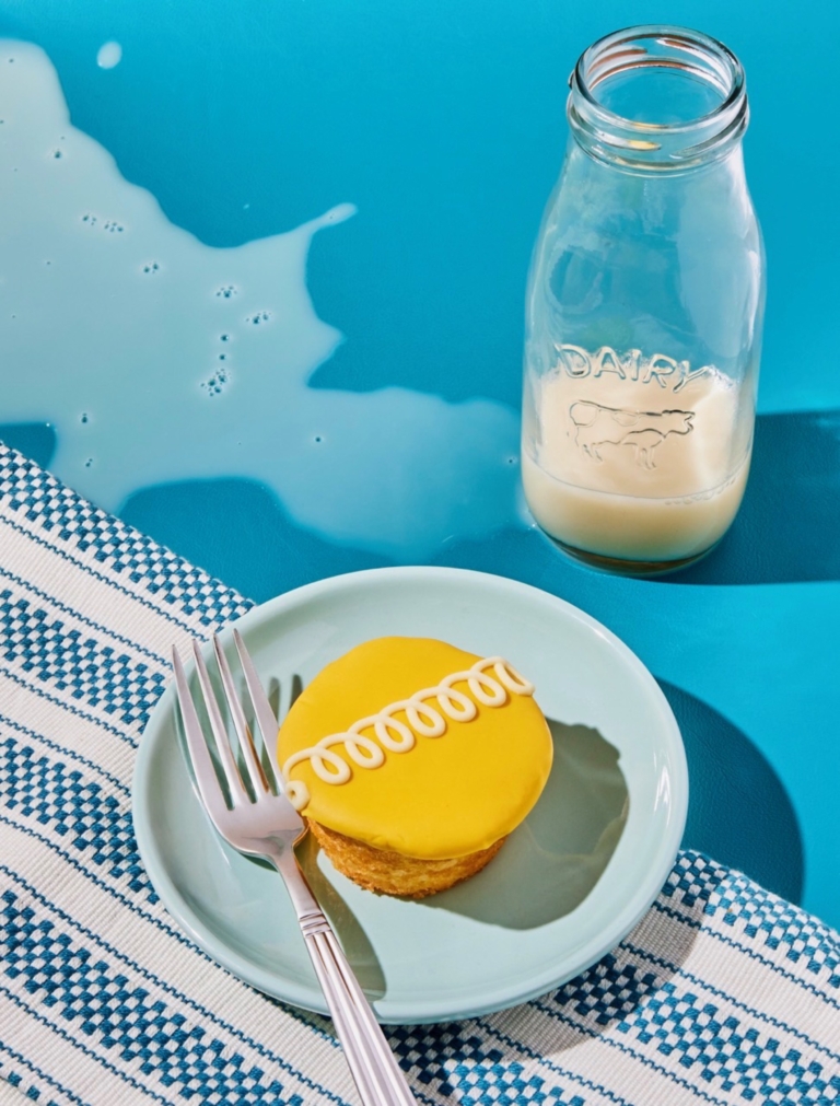 a cupcake on a plate next to a bottle of milk