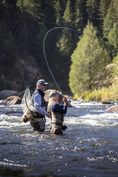 Woman and man fly fishing in a river surrounded by nature, captured for outdoor adventure and lifestyle brand photography by OMS Photography