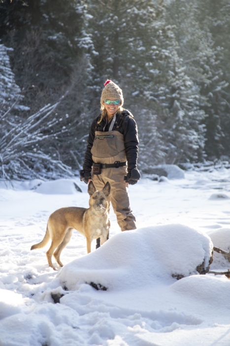 Woman in outdoor gear hiking through the woods with her dog, captured for adventure lifestyle photography by OMS Photography