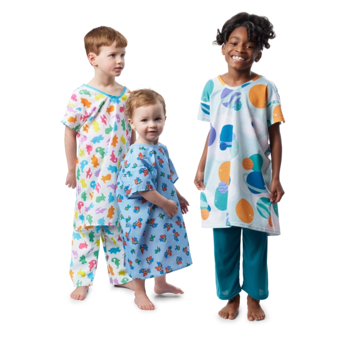 Children wearing colorful pediatric hospital gowns photographed on a white background by Marci Rhodes of OMS Photography – clean textile image showcasing fit, pattern, and comfort.