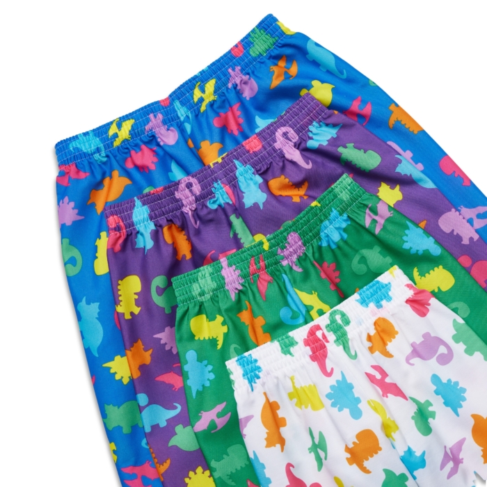 Close-up studio image of pediatric hospital gowns on white background by Marci Rhodes of OMS Photography – detailed textile shot highlighting fabric texture, stitching, and playful patterns.