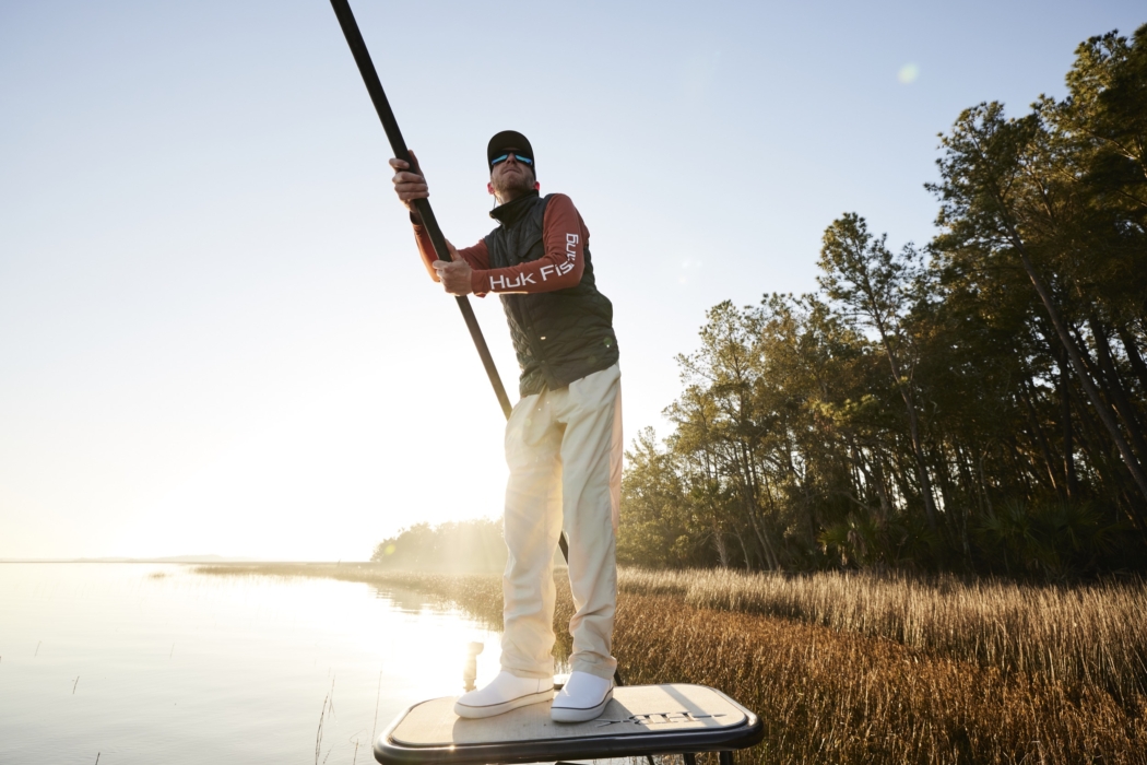 High-resolution image of man fishing on a boat wearing HUK gear, captured for outdoor and lifestyle brand marketing by OMS Photography