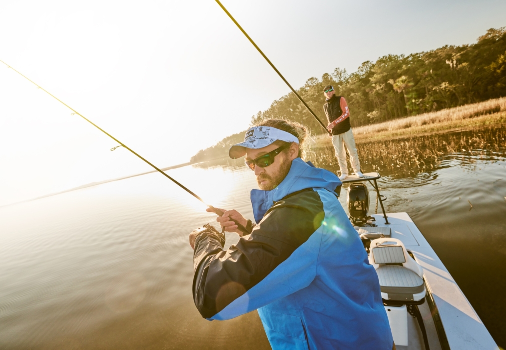 High-resolution image of two men fishing on a boat wearing HUK gear, captured for outdoor and lifestyle brand marketing by OMS Photography