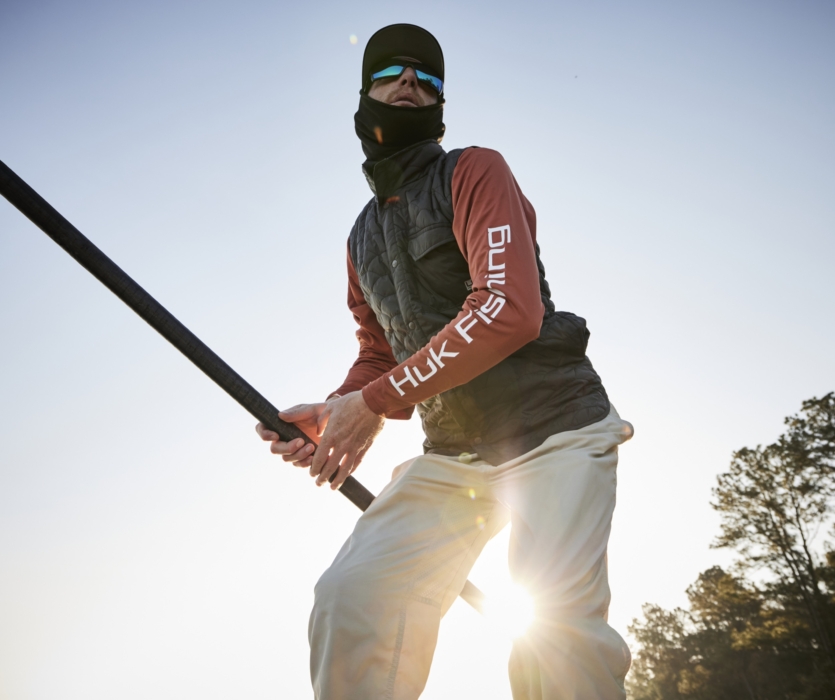 High-resolution image of man fishing on a boat wearing HUK gear, captured for outdoor and lifestyle brand marketing by OMS Photography