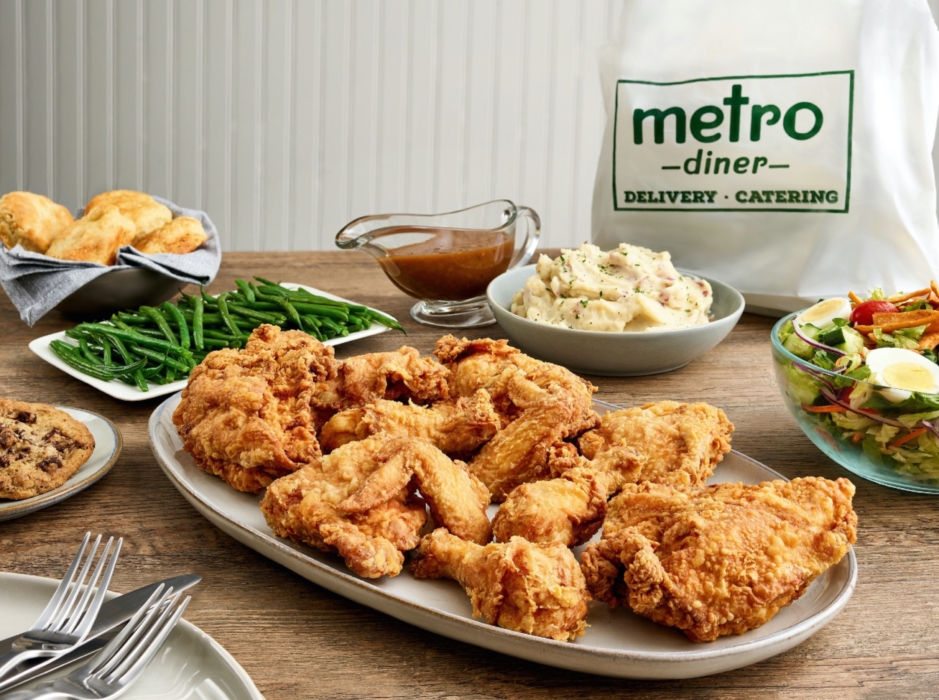 Family-style spread of chicken, salad, mashed potatoes, green beans, and rolls on plates, showcasing Metro Diner’s delivery and to-go options, photographed by OMS Photography