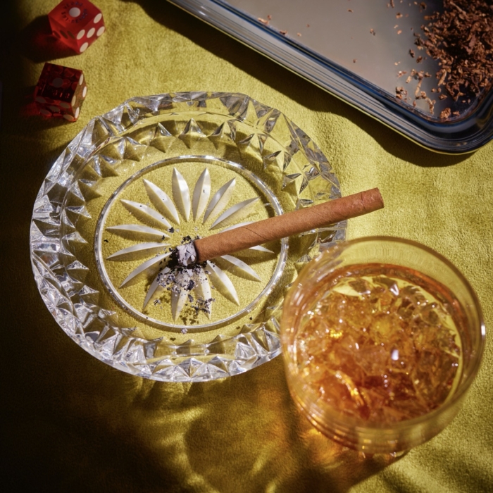 a glass with alcohol and a cigar on it
