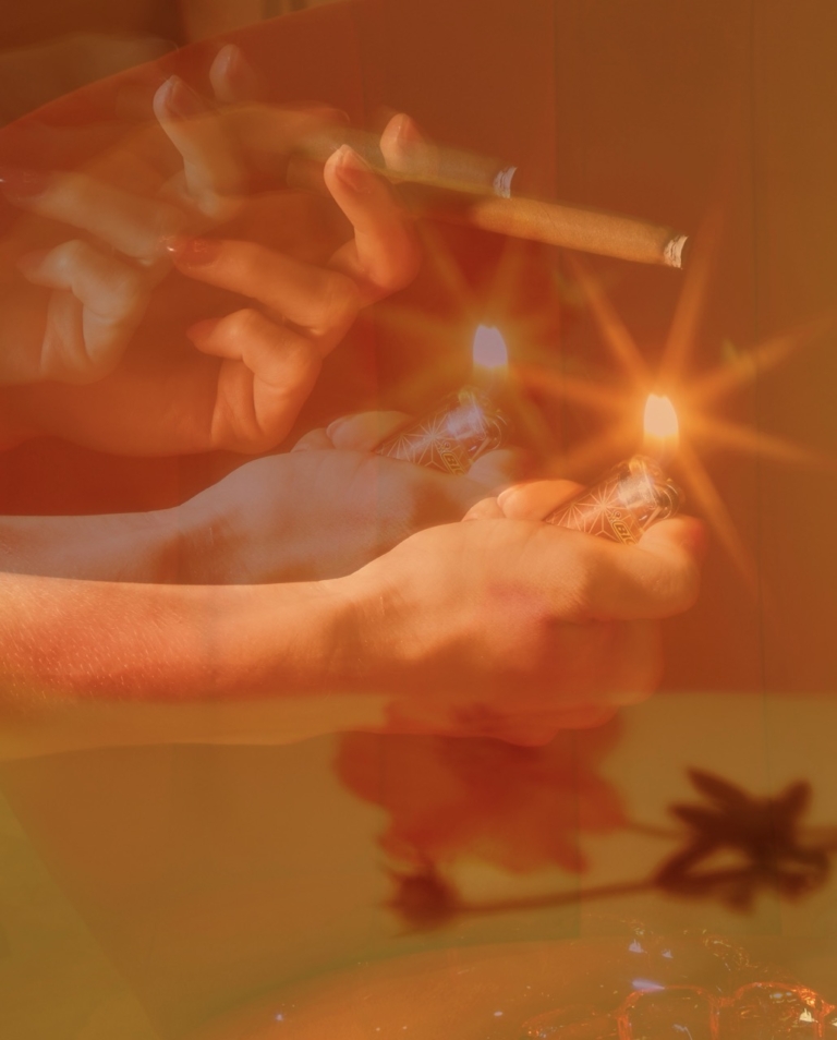 a person holding a cigar and lit lighters