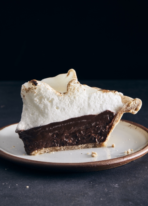 Slice of chocolate pie on a plate against a dark background, styled and photographed for food advertising by OMS Photography