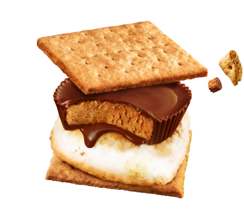S’more made with graham crackers, toasted marshmallow, and a melting peanut butter cup on a white background.