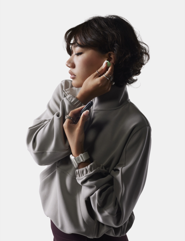 Woman in grey turtleneck touching face wearing watch and jewelry, on-model commercial fashion and accessories photography by OMS Photo