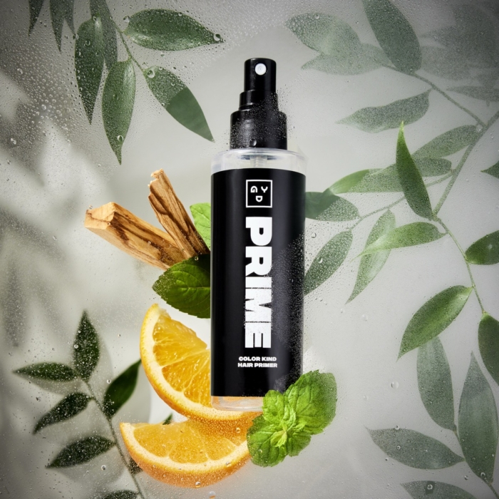 PRIME cosmetic spray bottle photographed in a botanical flat lay with citrus slices, cinnamon sticks, and green leaves