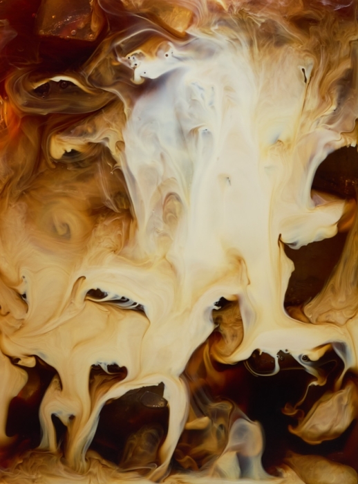Abstract macro photograph of Horizon Organic coffee creamer swirling into dark coffee, captured with high-speed liquid photography.