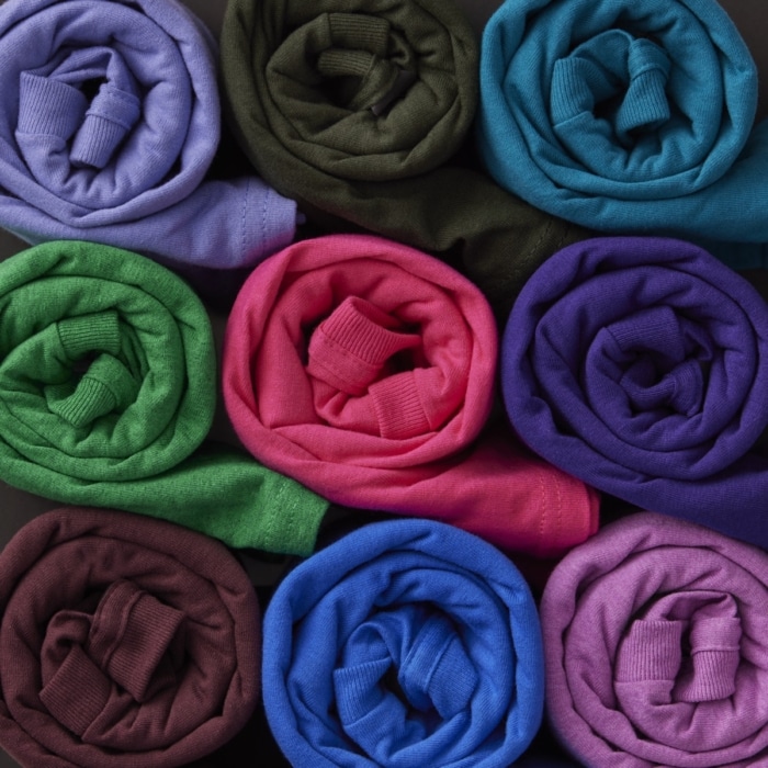 Rolled fabric in multiple colors arranged in a grid showing apparel color options