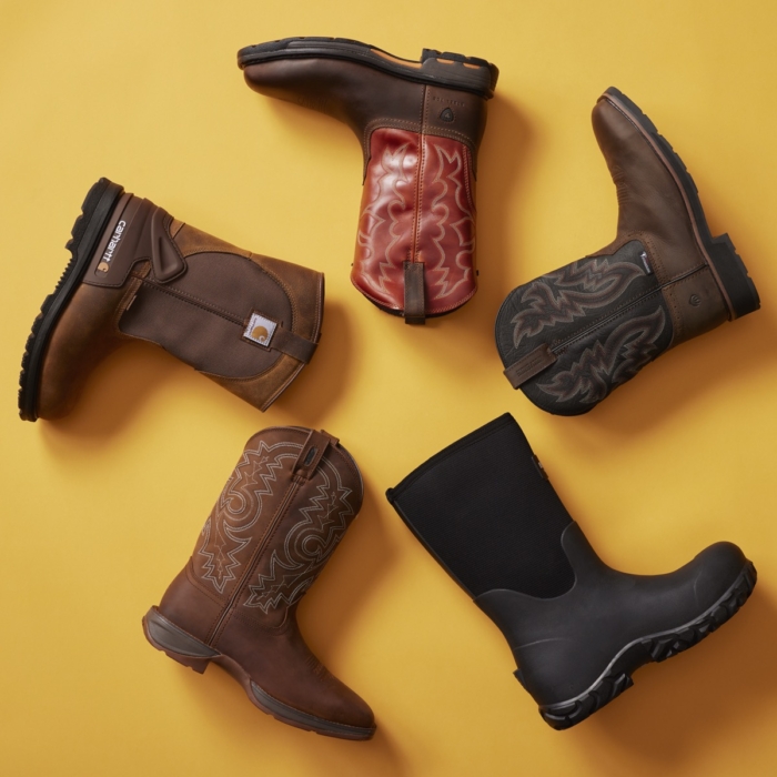 Five pairs of Carhartt work boots in various styles arranged in a flat lay on a bright yellow background