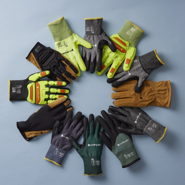 Assortment of Carhartt work gloves in multiple styles and colors arranged in a circular flat lay on a gray background
