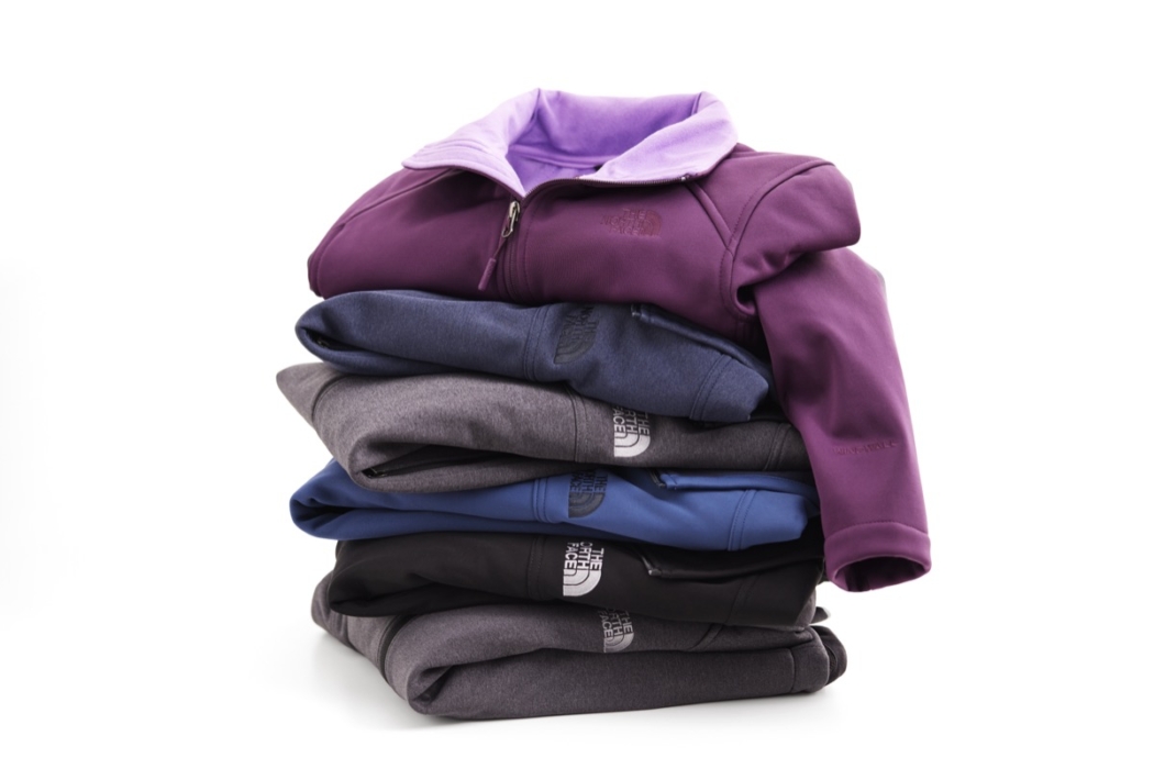 Stack of folded hoodies in neutral colors arranged neatly for product display