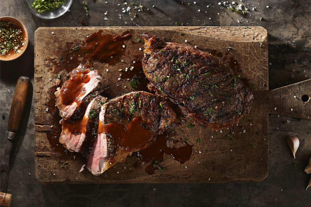 Sliced steak with herb butter and pan sauce — commercial food photography by OMS Photo