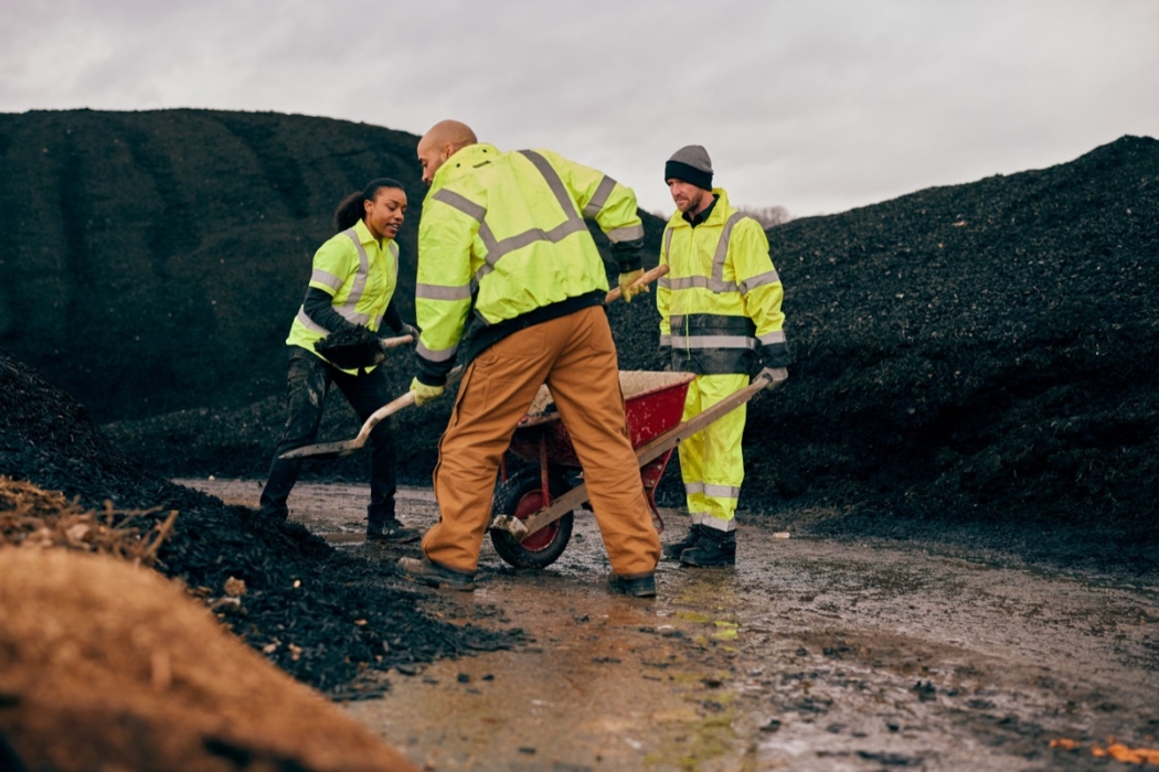 Group of workers in high-visibility jackets working together outdoors