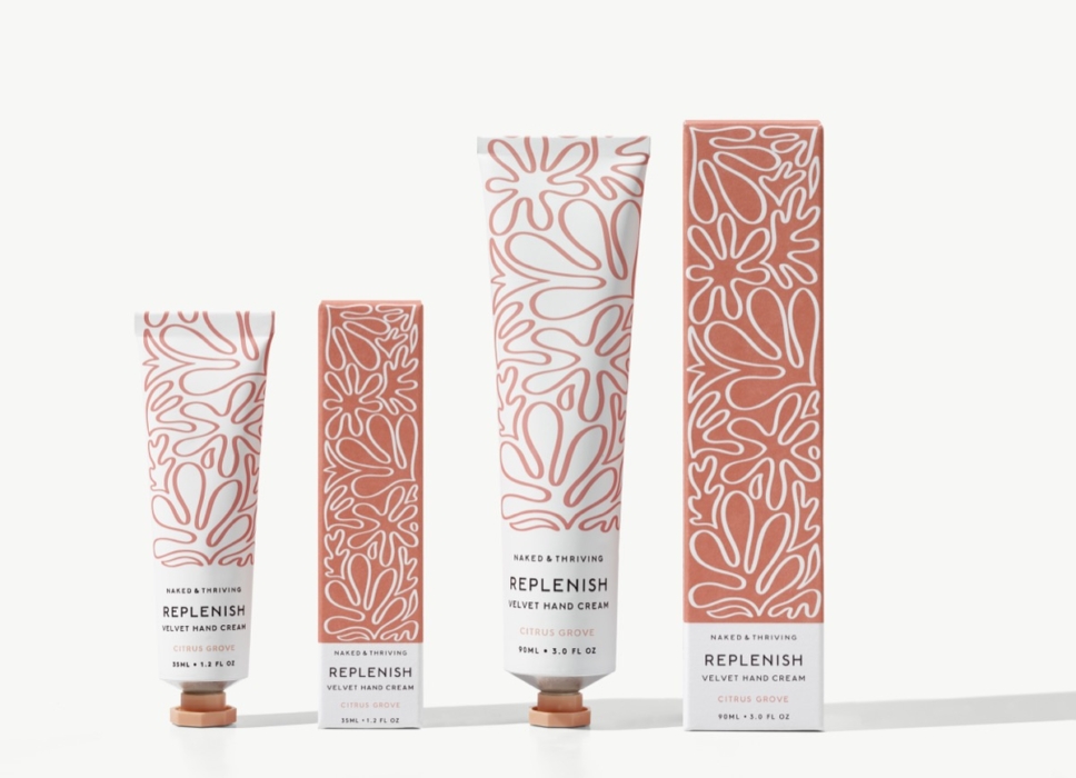 Naked & Thriving Replenish hand cream tubes and boxes in pink floral packaging on white background