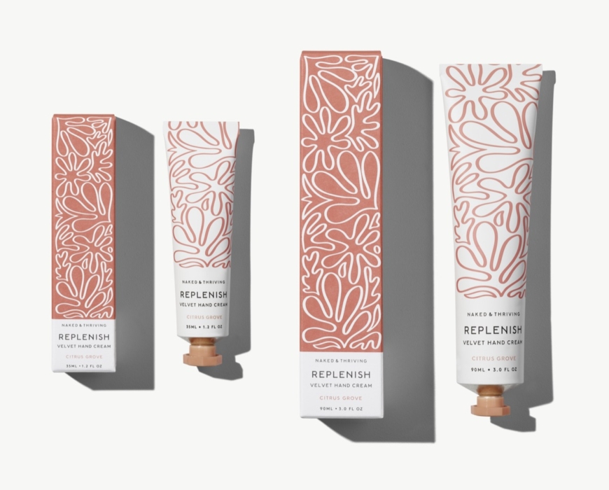 Naked & Thriving Replenish hand cream tubes and boxes in pink floral packaging angled view on white background