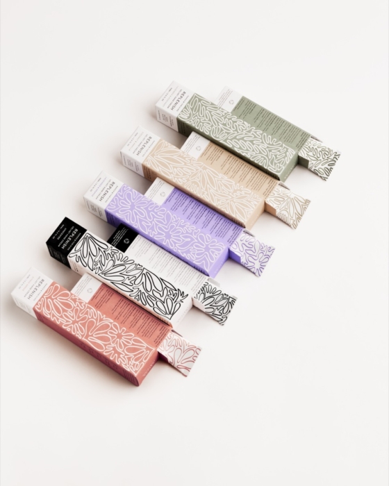 Naked & Thriving skincare tube collection in pastel colors flat lay on white background