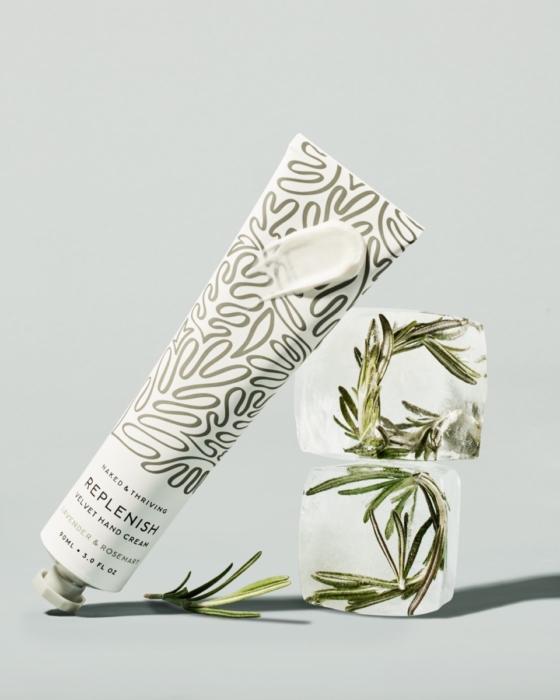 Naked & Thriving hand cream tube collection with olive branch on cream background