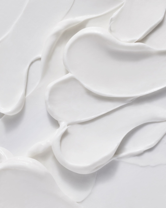 Close-up of Naked & Thriving moisturizer cream texture swirl on white background