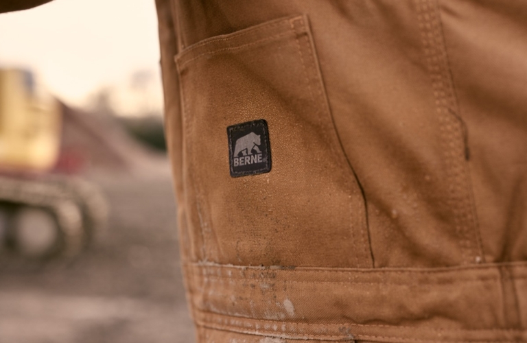 Close-up of brown workwear fabric showing pocket detail and stitching