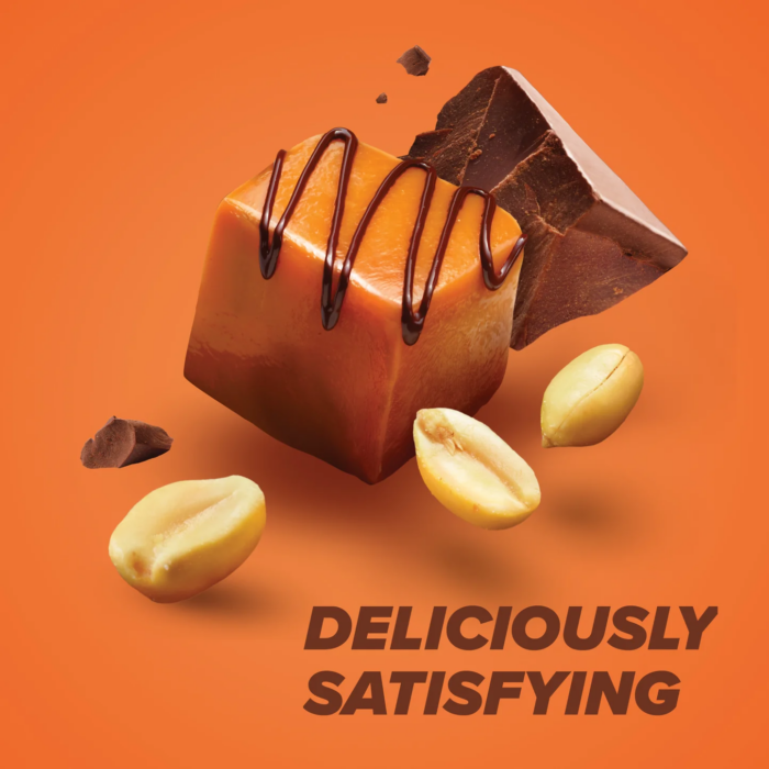 Unwrapped Pure Protein Chocolate Peanut Caramel protein bar with caramel drizzle and peanuts on orange background